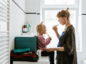 Mamá y niña en el baño cepillándose en el baño.