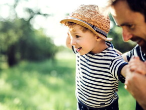 Niño haciendo equilibrio con su padre.