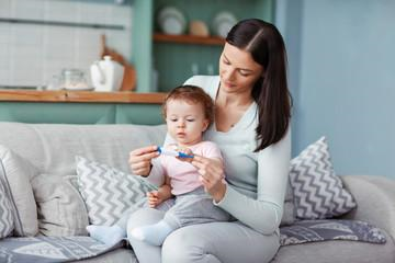 Una mamá revisando la temperatura luego de un episodio de vómito en bebés