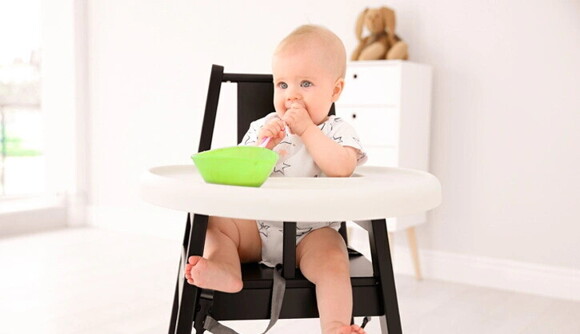 Un niño aprendiendo a comer compotas para bebés solos